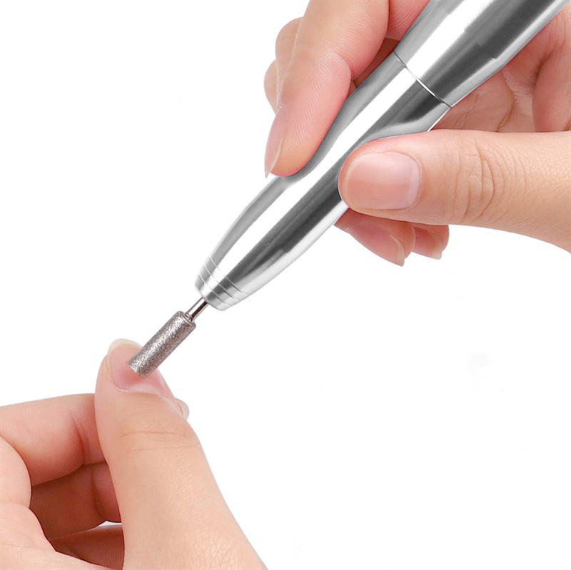 A person uses the UNIQ Compact Electric Nail File Kit, a portable manicure tool from UNIQ, to shape their nails precisely with its efficient e-file design.